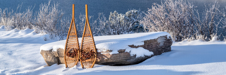 Fototapeta premium winter scenery of Horsetooth Reservoir in northern Colorado with classic Huron snowshoes, panoramic web banner