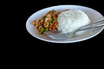 Stir fried Thai basil with minced pork on black background.