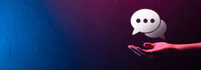 Businessman holding a message icon, bubble talk notification sign in his hands. Chat icon, sms icon, comments icon, speech bubbles