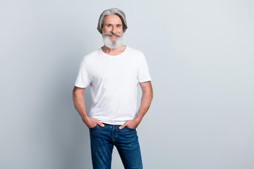Photo of pretty charming man pensioner dressed white t-shirt smiling walking arms pockets isolated...