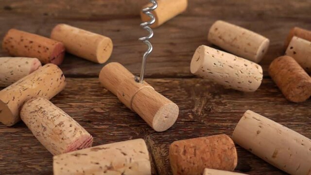 Wine corks and falling corkscrew on wooden old boards. Slow motion.