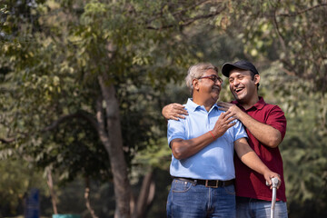 Cheerful grandfather spending leisure time with son at park

