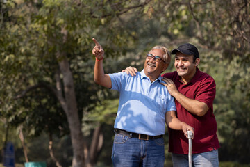 Cheerful grandfather spending leisure time with son at park
