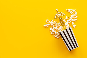 Golden film award statue with popcorn. Best movie concept