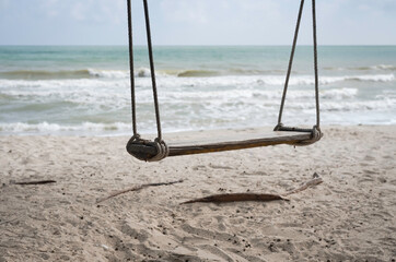 Wooden Swing hanging with rope on the beach