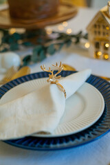Fototapeta na wymiar Stylish light Christmas table setting with golden cutlery. Festive feasts. Decorations on the New Year's table.