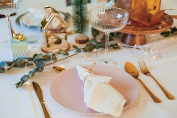 Stylish light Christmas table setting with golden cutlery. Festive feasts. Decorations on the New Year's table.