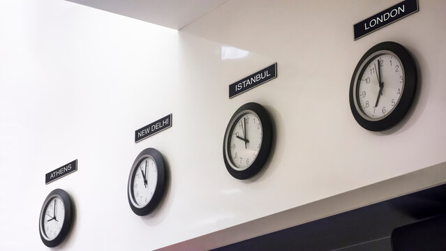 Time zone clocks in a row on wall