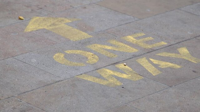 Close Up Shot of Feet Walking Over One Way Pavement Marking. High quality video footage