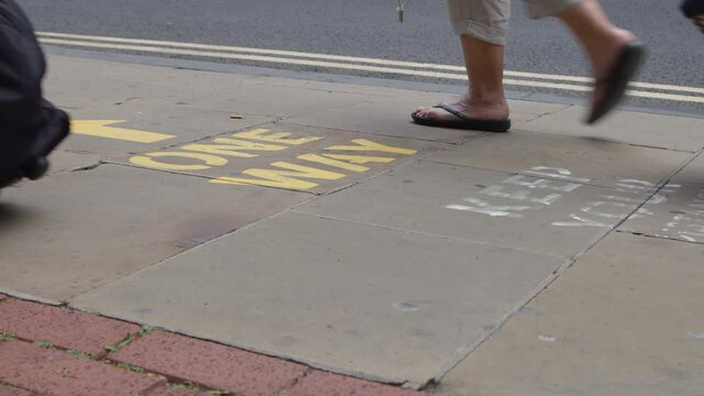Close Up Shot of Feet Walking Over One Way Pavement Marking In Oxford England. 
