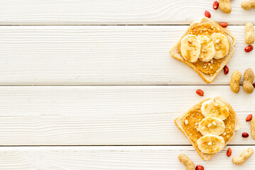 Smooth peanut butter on sandwiches with nuts. Top view