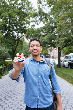 USA, New York, New York City, Portrait Of Smiling Man With Vote Badge In City