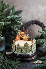 New Year's cake with vanilla cream decorated with Christmas tree cookies. Festive cake on the table with nobilis branches.