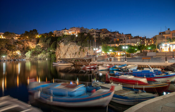 Greece, Crete, Boats in harbor and village on cliffs