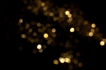 Golden blurred bokeh lights on black background. Glitter sparkle stars for celebrate. Overlay for your design