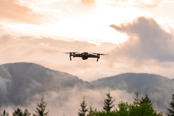 Fototapeta na wymiar Drone with camera flying over mountain fields.