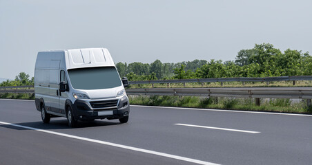 White modern delivery small shipment cargo courier van moving fast on motorway road to city urban suburb.  Distribution and logistics express service. Mini bus driving on highway day. banner © Bojan