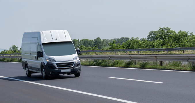 White modern delivery small shipment cargo courier van moving fast on motorway road to city urban suburb. 
Distribution and logistics express service. Mini bus driving on highway day. banner