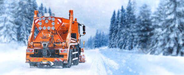 Salting highway maintenance. Snow plow truck on snowy road in action. Hard weather condition in...