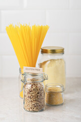 Gluten-free pasta and cereals in a glass jar on the table. Pasta made from corn-rice flour for diet food.
