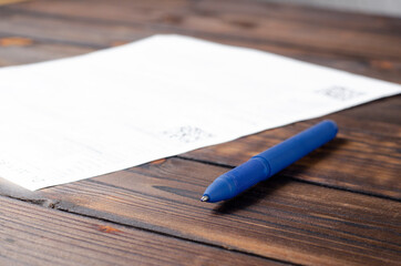 Pen and notebook on the table. Clear sheet. Signature. Contract. On a wooden table.