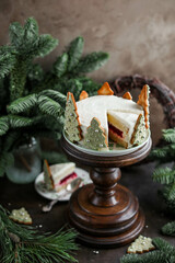 New Year's cake with vanilla cream decorated with Christmas tree cookies. Festive cake on the table with nobilis branches.