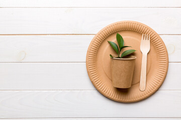 set of empty reusable disposable eco-friendly plates, cups, utensils on light white colored table background. top view. Biodegradable craft dishes. Recycling concept. Close-up