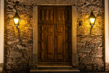 Wooden door with stone border and lanterns of a church in Colonia del Sacramento, Uruguay