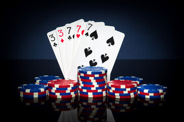 Playing cards in poker game with full house or full boat combination. Chips and cards on black table. Successful and win.