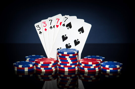 Playing cards in poker game with full house or full boat combination. Chips and cards on black table. Successful and win.