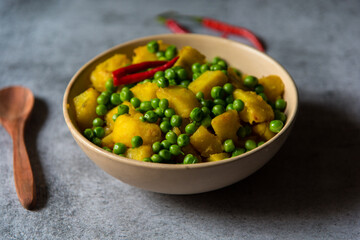 Indian food menu alu matar or fried peas potato in a bowl. Close up.