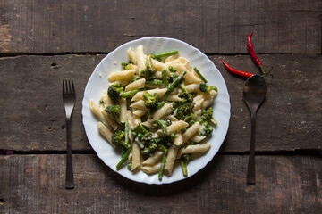 Italian delicacy penne pasta in cheese sauce in a plate. Top view.