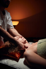 Woman on a massaging, chiropracting table, treatment of body and face skin tension.