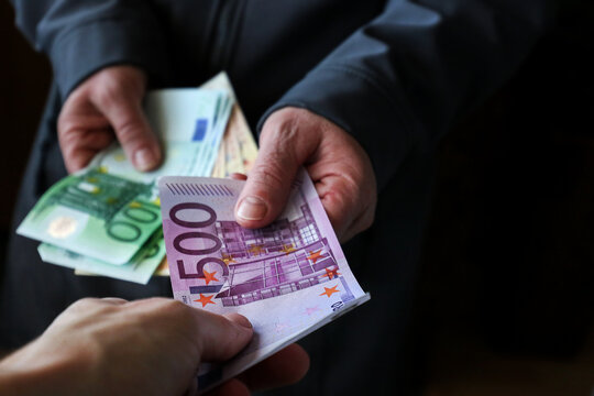 Black money or exchangeing euro, hands holding 500euro. Man give money. Coruption. close up shot.
