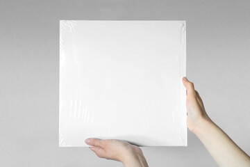 Hands holding white vinyl cover. White mockup. Retro Disco design. Front view.