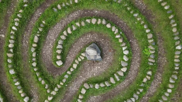 A round stone labyrinth with a top view, the camera rotates.