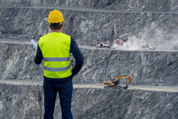 Engineer in the background of an open pit or coal mine, quarry for mining minerals as an industrial concept