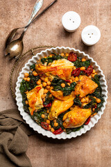 One pot chicken with kale, chickpeas and sun-dried tomatoes. Top view, vertical image.