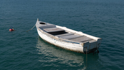 Fototapeta na wymiar A lonely white boat in the bay