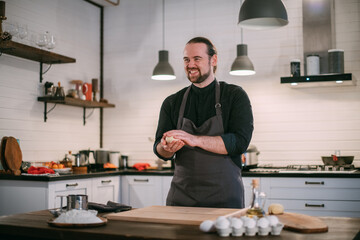 A male chef prepares noodles at home in the kitchen.