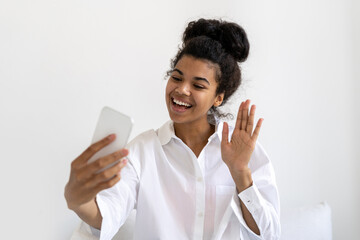 Positive african american woman with smartphone making video call