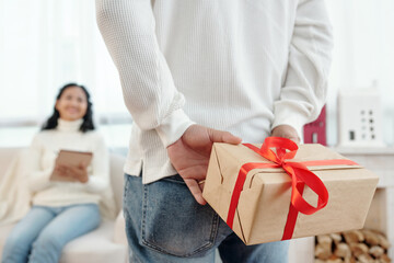 Man hiding New Year present for wife behind back