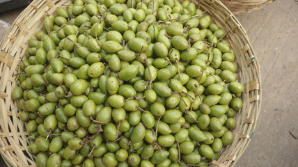Lots of green raw olives in the traditional bowl to sell in super market of Dhaka, Bangladesh