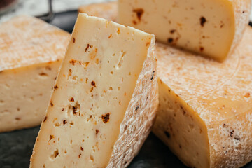 Pieces of pecorino cheese with dried tomatoes. Traditional italian hard cheese still life