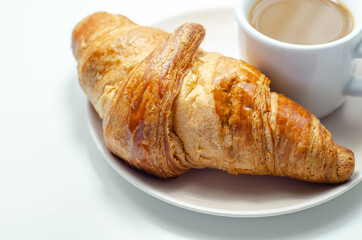 Croissant with chocolate on a plate with coffee in a cup