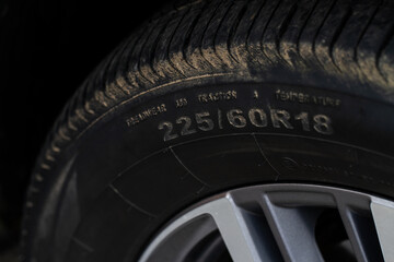 Close up view of tire with tire width, height and wheel diameter designation. Tire size types labels.