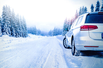 Car on winter snowy road in mountains. Winter tire test. Holidays adventure concept.