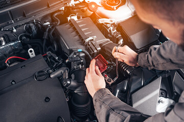Auto Repair Shop or Auto Service. Replacing a car battery. Disconnecting the car battery terminal....