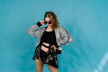 Young lady cheerleader posing in the studio, isolated on red and blue