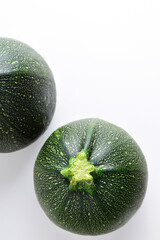Vertical shot and zenith view, round zucchini on light background. Copy space.